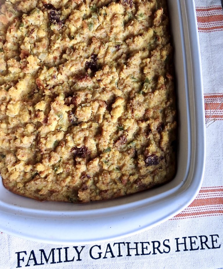 Cooked cornbread in a white casserole dish on an orange and white striped place mat.