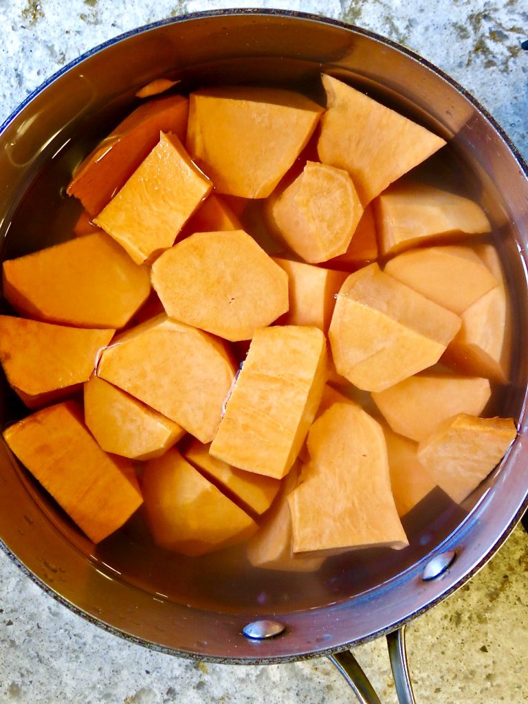 Cubed sweet potatoes in a pot of water to boil for Fresh Sweet Potato Casserole.