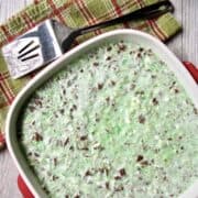 Red and whiter casserole dish filled with the lime Congealed Salad, Cherry Or Lime Flavored.