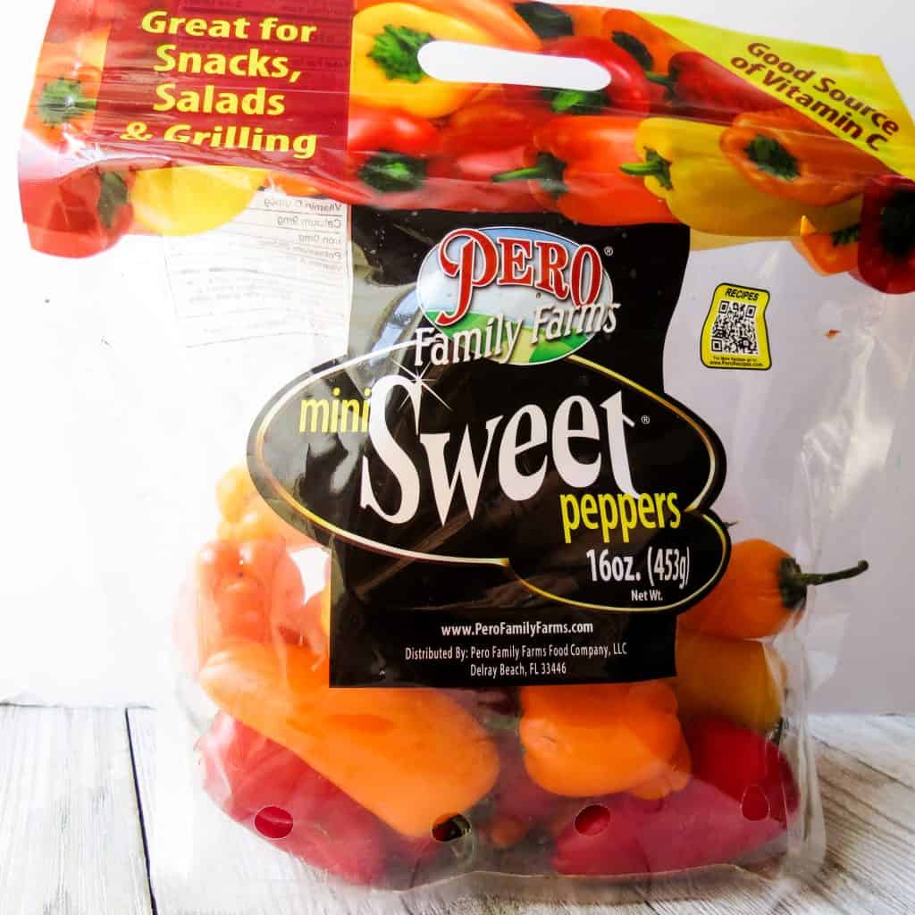 A bag of sweet red, orange, and yellow mini peppers.