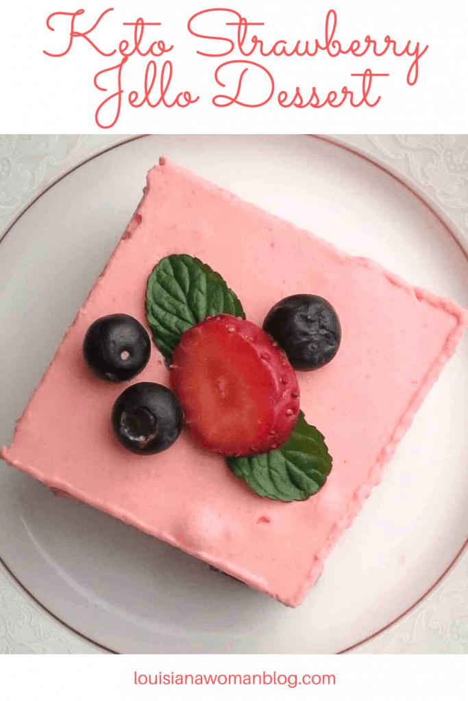 A square of pink jello dessert with berries on top.