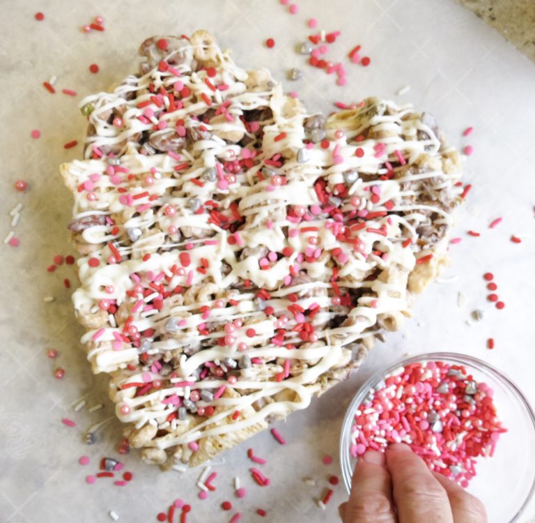 Heart shape molded Valentine Candy Crunch topped with sprinkles.