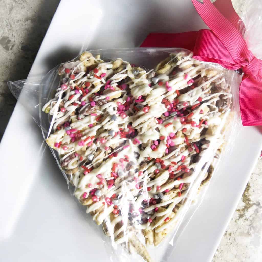 Heart shaped Valentine Candy Crunch in a plastic bag and a pink bow.