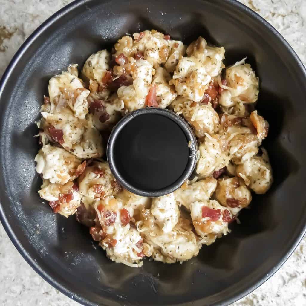 A bundt pan filled with Savory Monkey Bread, Two Ways before baking.