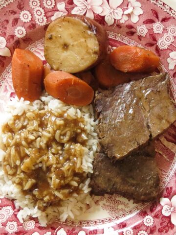 A red and white toile plate of rice and gravy, roast, carrots and potato for Rice and Gravy, A Cajun's Staple