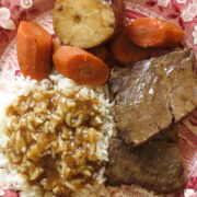 A red and white toile plate of rice and gravy, roast, carrots and potato for Rice and Gravy, A Cajun's Staple