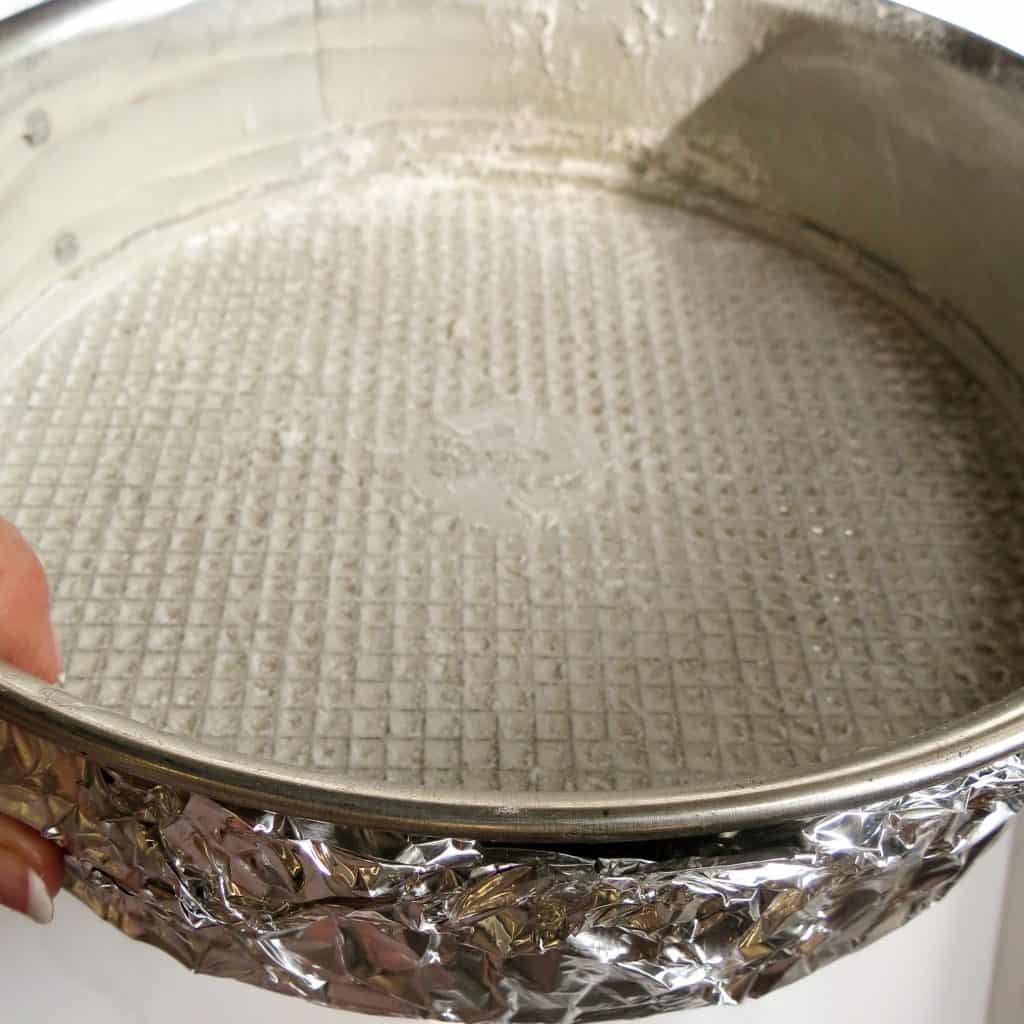 A prepared spring form pan wrapped in foil around the outside.