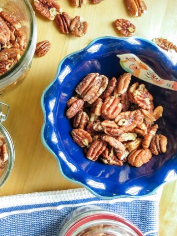 Roasted pecans in different containers for storage and serving.