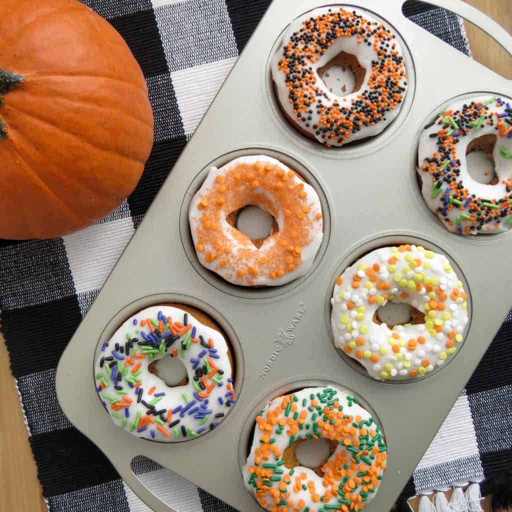Iced and decorated donuts in a donut pan.
