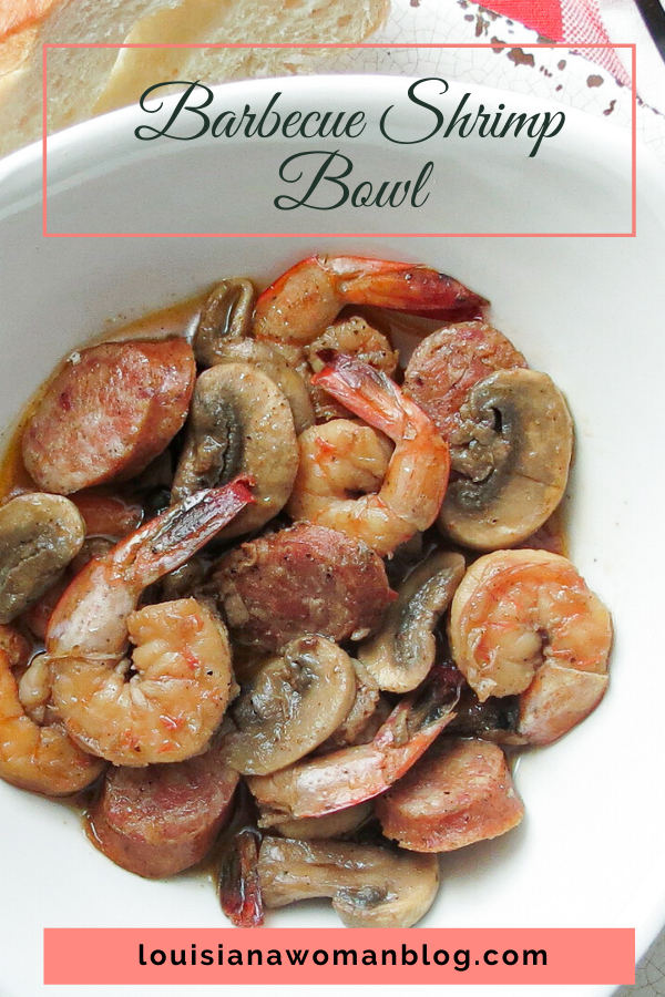 A bowl full of barbecue shrimp with mushrooms and smoked sausage.