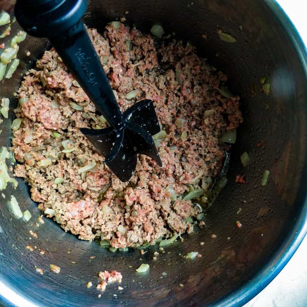 A meat chopper browning ground meat in the Instant Pot.