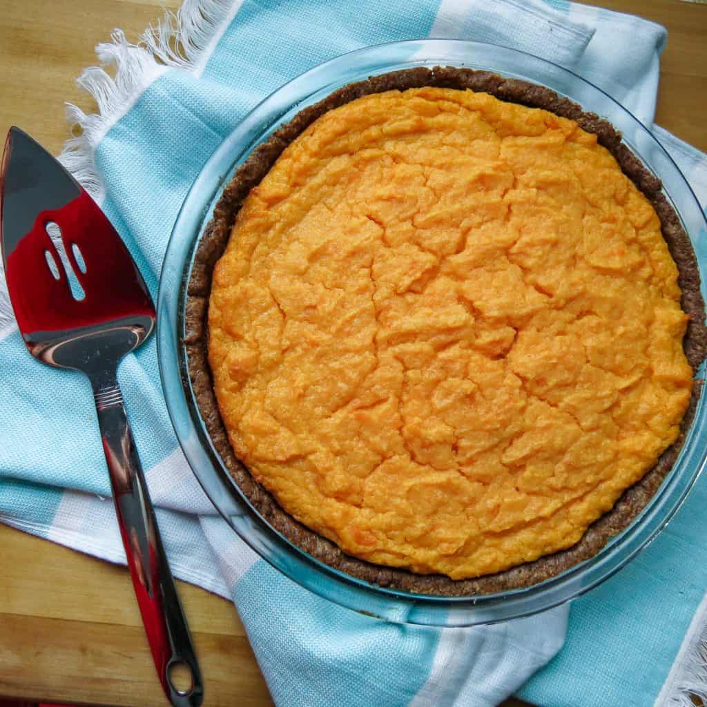 A sweet potato pie with a pie cutter.