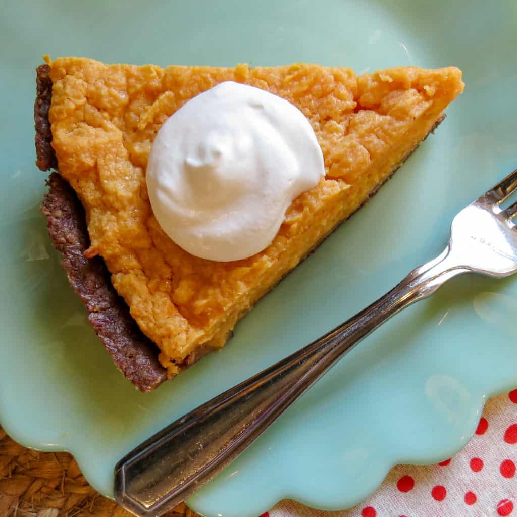 A piece of No Sugar Sweet Potato Pie with a dollop of whipped cream.