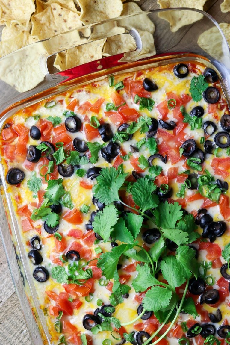 A dish of cheesy dip with fresh celantro on top.