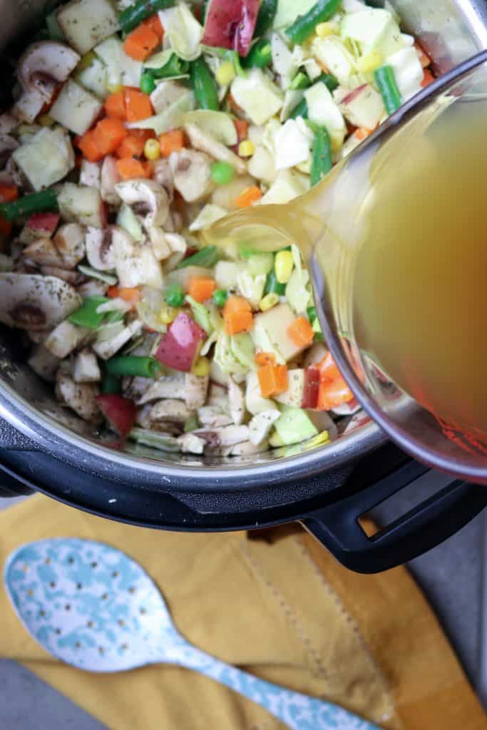 Pouring stock into pot ingredients.