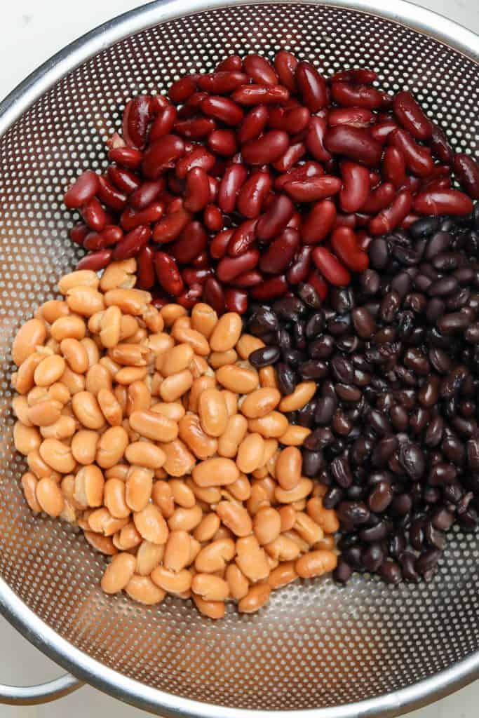 kidney Beans, black beans, and pinto beans draining in a strainer.