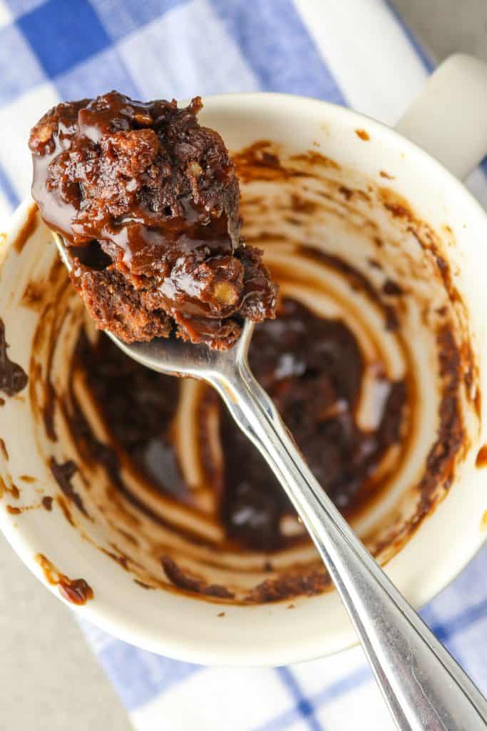 A spoonful of Fudgy Chocolate Mug Brownie over a dish.