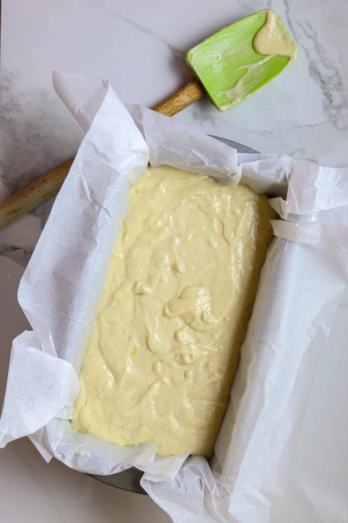 A parchment paper lined loaf pan filled with banana bread batter.