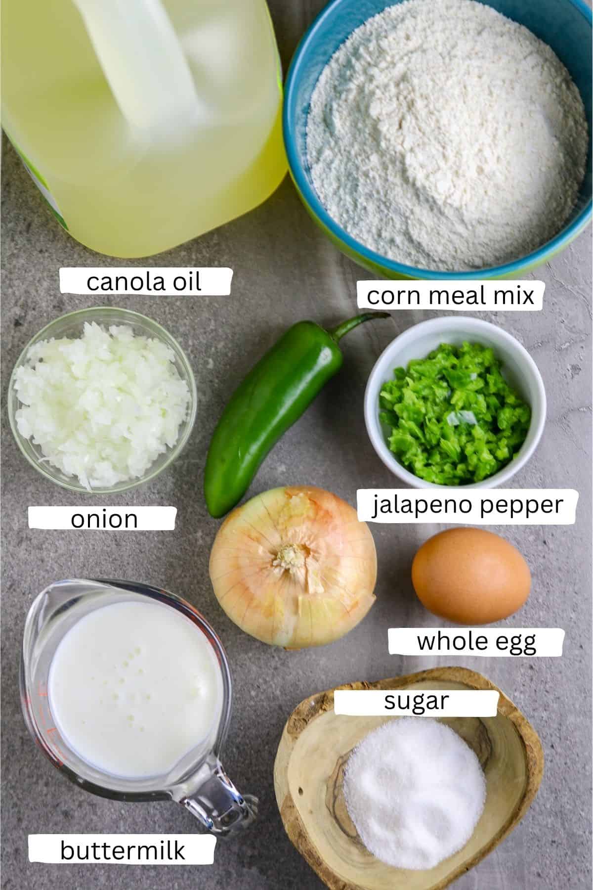 Individual ingredients in containers of egg, corn mial mix, onion, jalapeno pepper, egg, buttermilk, and sugar for making hush puppies.