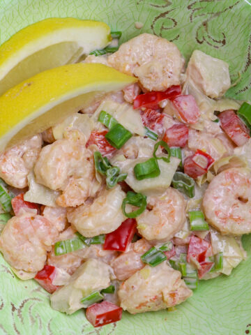 A green bowl with shrimp salad in it.