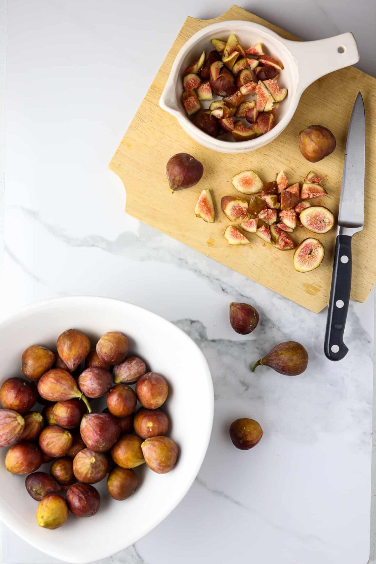 A cutting board with cut up fresh figs.