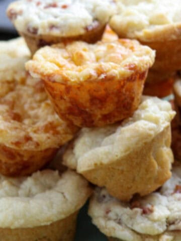 A stack of mini muffins on a green plate.