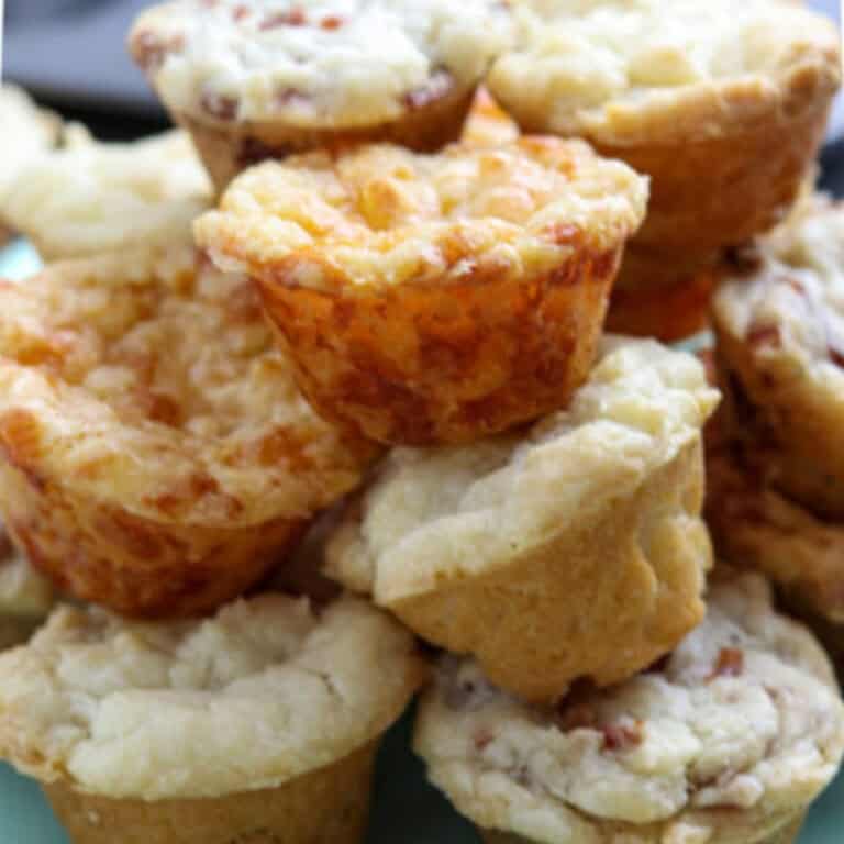 A stack of mini muffins on a green plate.