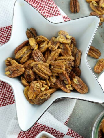 Roasted pecans in a star-shaped bowl.