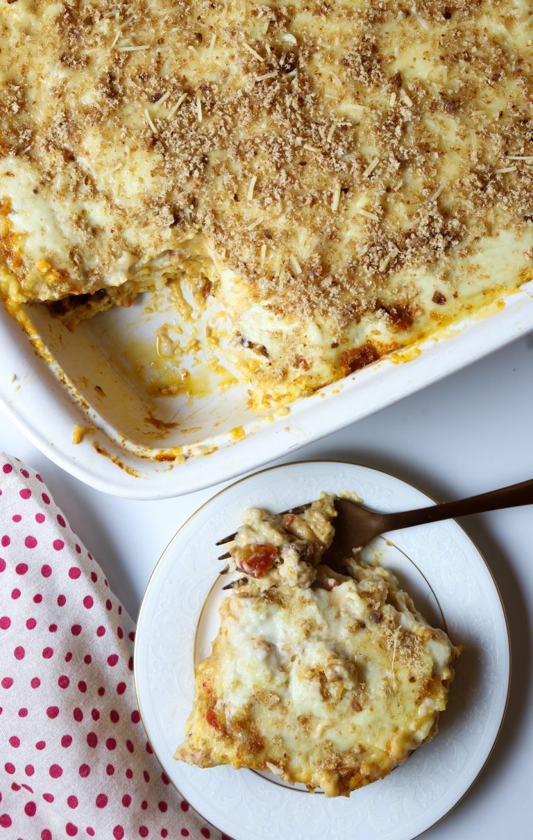 A plate of lasagna with a forkful and a casserole dish of lasagna.