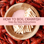 A pile of boiled crawfish and a bowl of dip in the middle.