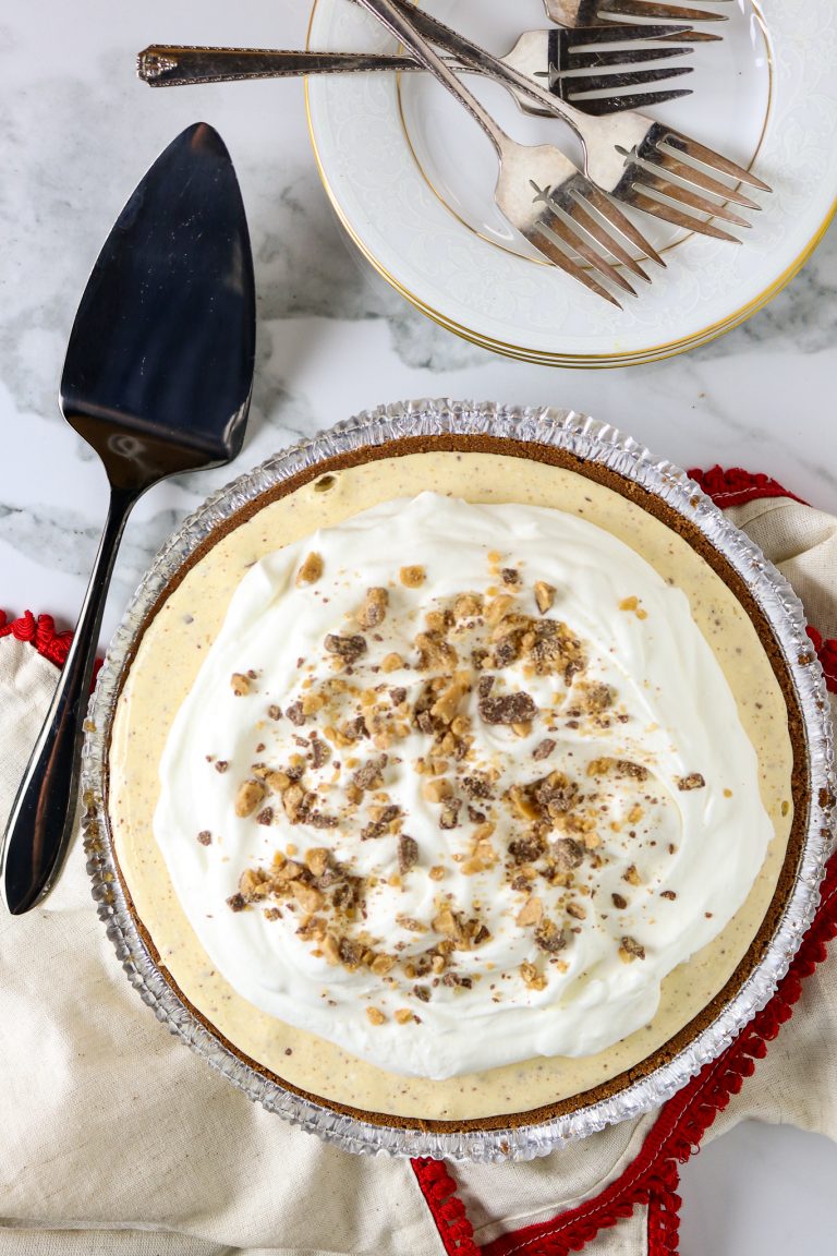 A toffee ice cream pie with a pie server and plates.