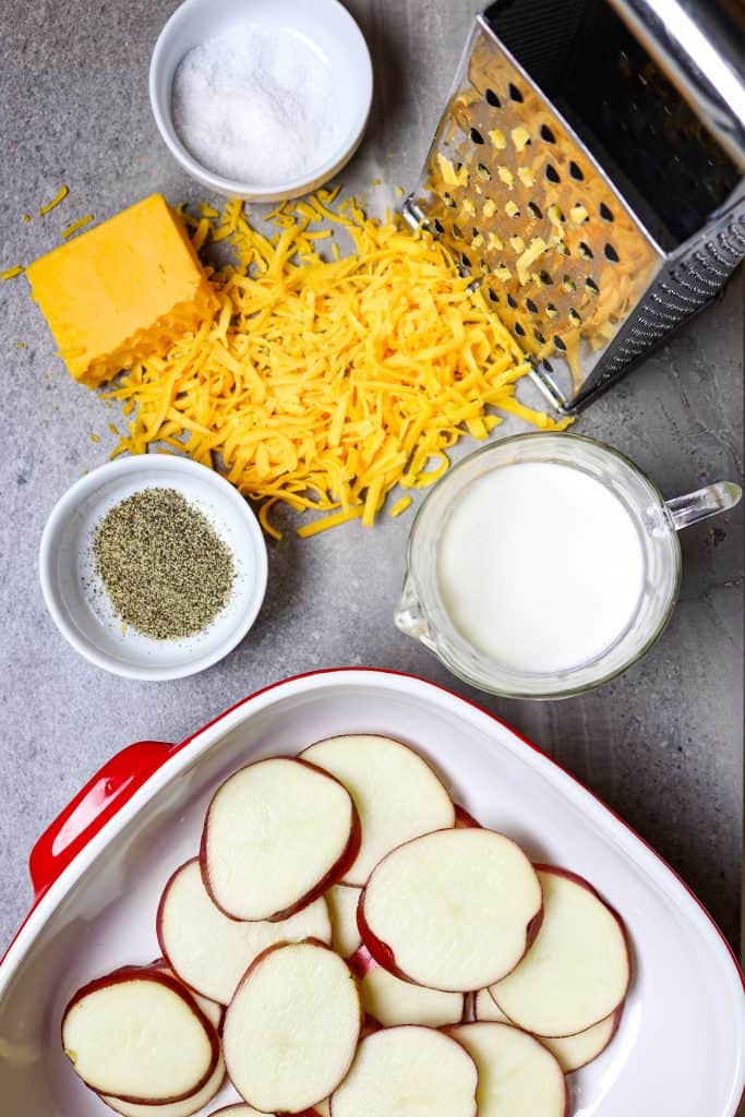 Ingredients of potatoes, cheese, and cream for a Cheese Potato Casserole.