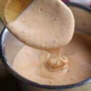 A wooden spoon stirring Louisiana Comeback Sauce.