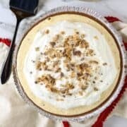 A toffee ice cream pie with a pie server and plates.
