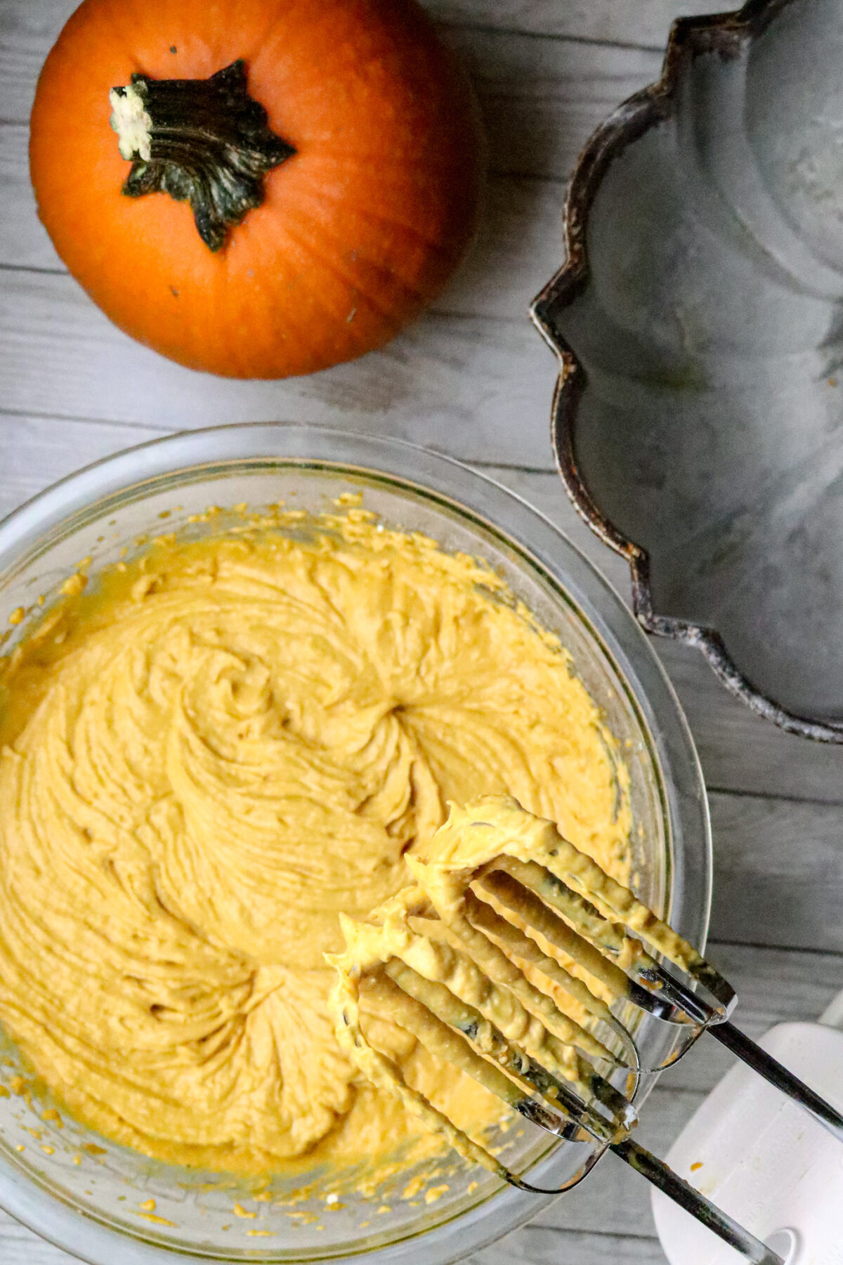 A bowl of 2-Ingredient Pumpkin Cake batter with mixer.