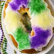 A King Cake with colored sugars of purple, green, and gold.