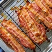 A pan with a rack of cooked bacon slices.