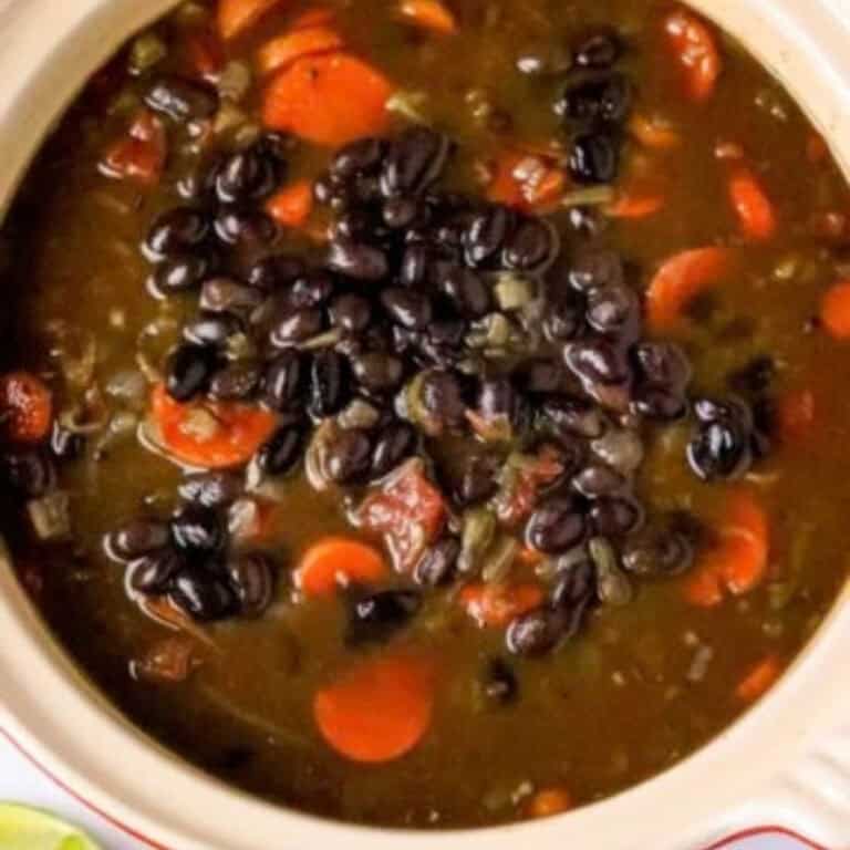 A pot of black bean soup with carrots.