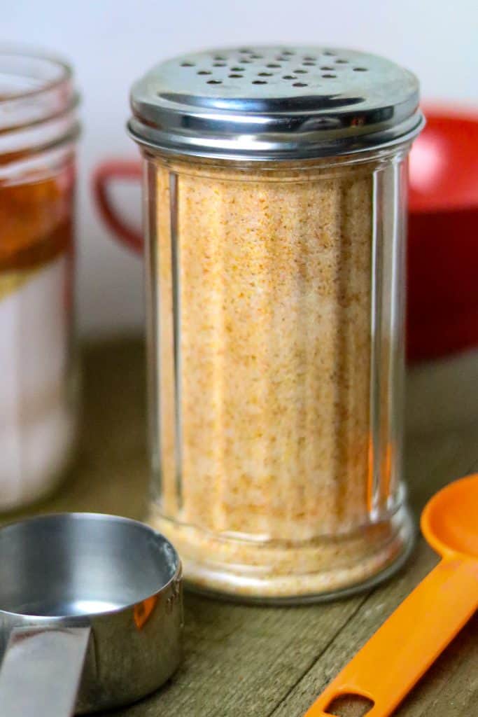 A glass shaker jar filled with House Seasoning Blend.
