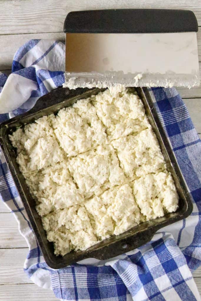 A square pan of raw biscuit dough for Easy Buttermilk Biscuit Recipe
.