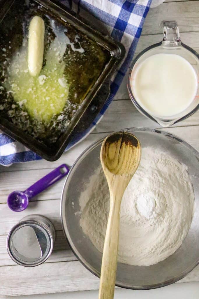 Flour in a bowl with a melted stick of butter in a pan for Easy Buttermilk Biscuit Recipe