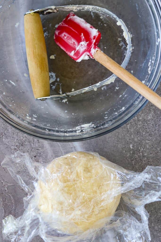 A ball of pie dough wrapped in plastic wrap for Classic Homemade Pie Crust.
