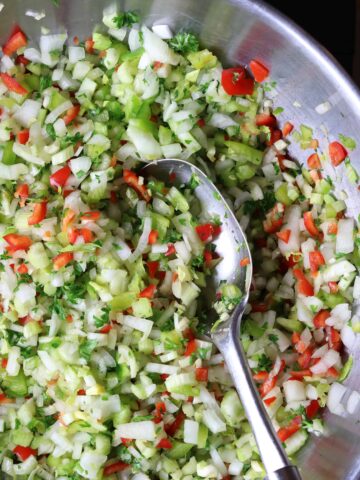A bowl of chopped vegetables with a spoon in it.