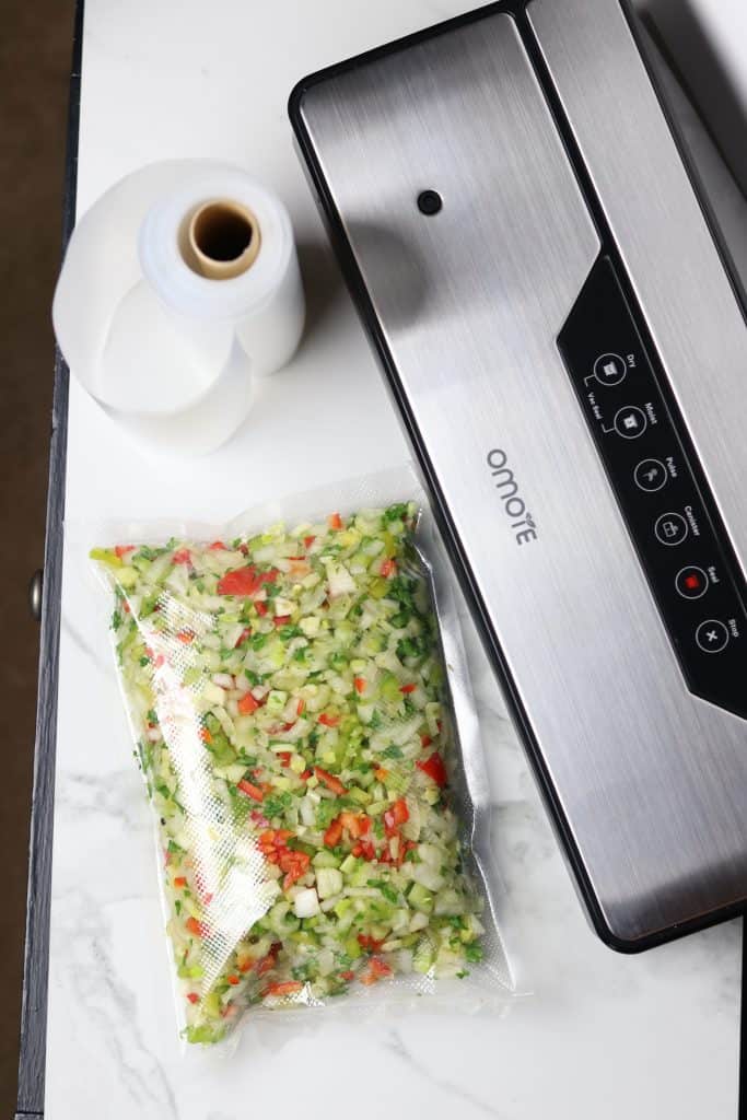A package of Creole Seasoning Blend Recipe next to an Omote Vacuum Sealer.