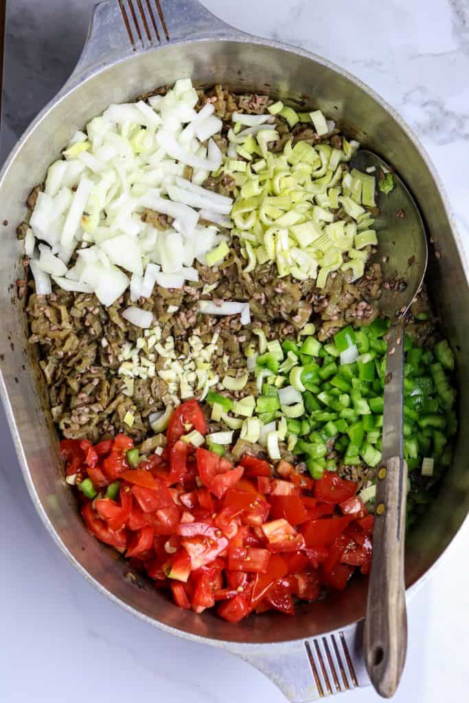 A large pot of cooked okra and fresh vegetables.