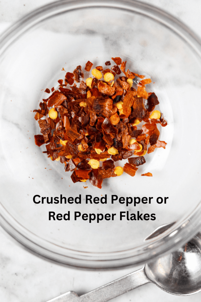 Red pepper flakes in a glass bowl.