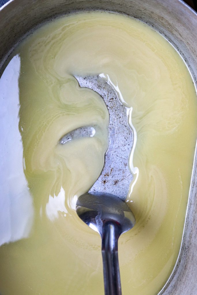 A spoon stirring flour and oil for a roux.