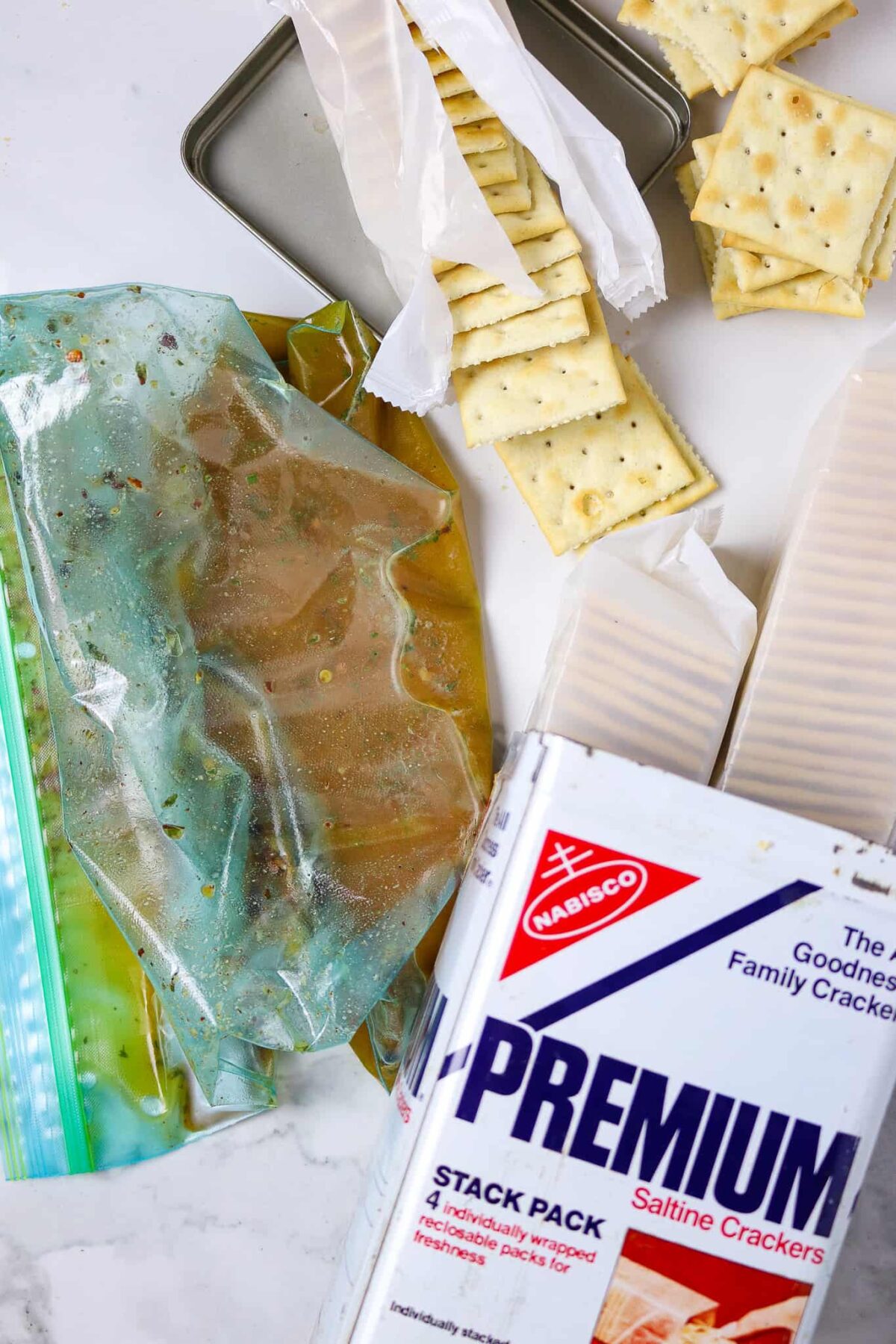 A plastic bag of seasonings with packages of saltine crackers for Cajun Ranch Fire Crackers.