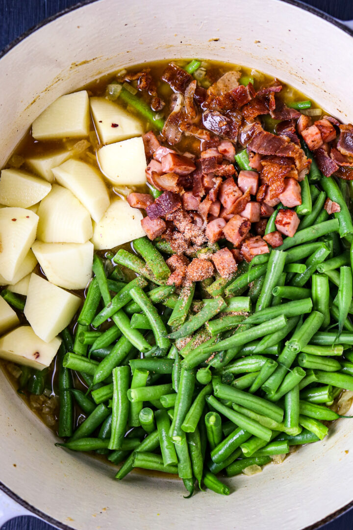 A pot of green beans, potatoes and ham.