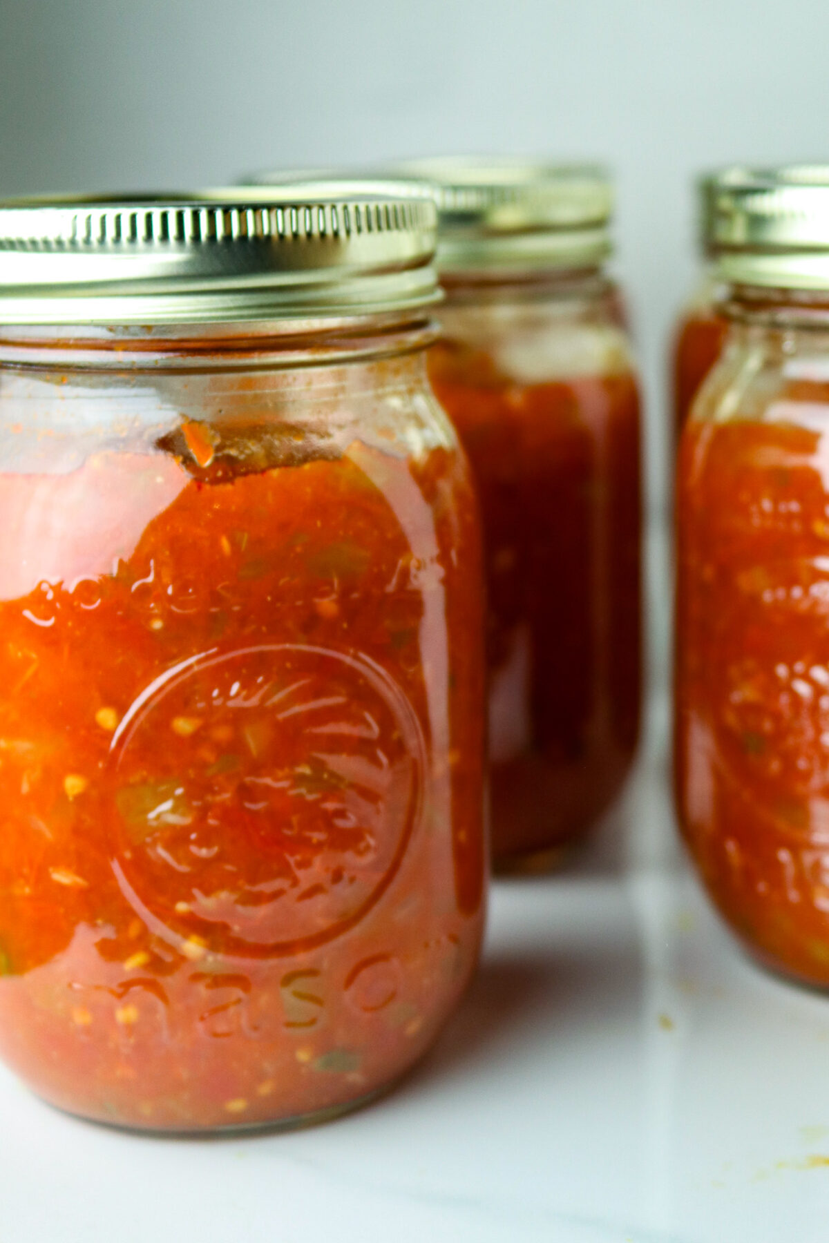Three jars of homemade tomato salsa.